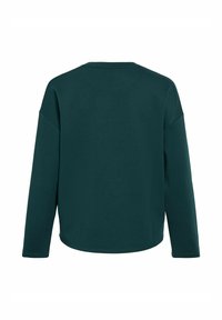 Camisa de manga larga verde oscuro con cuello redondo, corte relajado y puños acanalados. Textura de tela suave y sin patrones visibles.