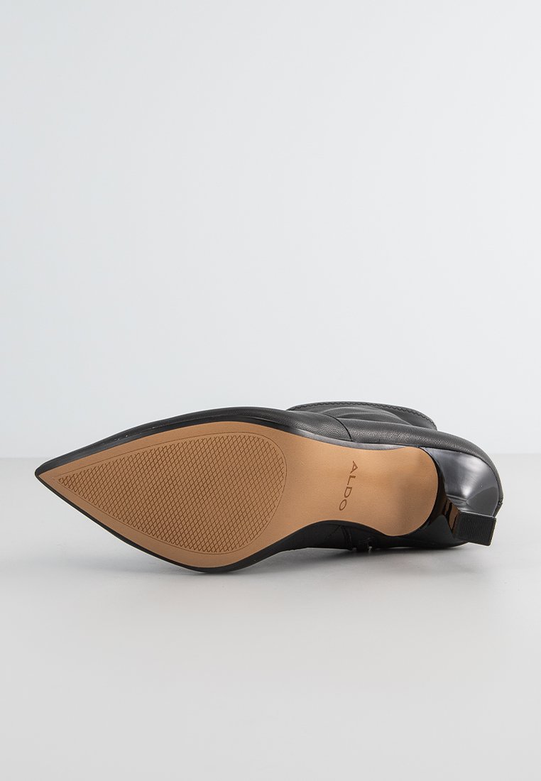 Schwarze Leder-Ankleboots mit spitzem Zehenbereich, glatter Textur, flachem Absatz und Gummisohle mit rutschfestem Profil. Markenlogo sichtbar.