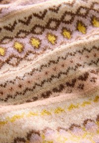 Tissu tricoté présentant un motif géométrique répétitif dans des tons de marron, rose et jaune, avec une texture douce, mettant en valeur des détails délicats.