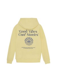 Un sweat à capuche jaune avec un grand graphisme en texte gris au dos portant l'inscription "Good Vibes Cool Stories" et un motif de soleil en dessous. En matière de coton.
