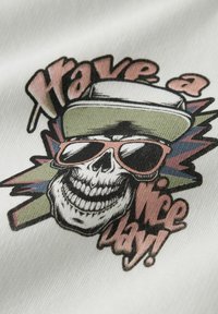 Grafisk T-skjorte med en hodeskalle iført solbriller og caps, i svart, hvitt og pastellfarger, med teksten "Ha en fin dag!"