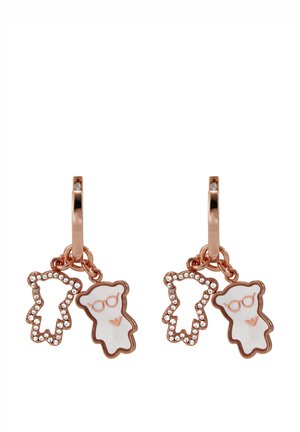 Los pendientes de aro en oro rosa presentan dos charms de osito de peluche, uno con gafas y acentos de cristal, y un acabado de esmalte blanco.