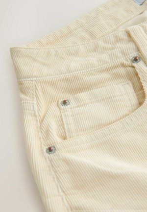 Cremefarbene Cordhosen mit vertikalen Streifen, einer Gesäßtasche mit einem silbernen Niet und einer strukturierten Oberfläche.