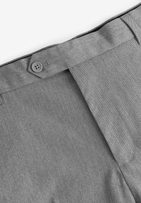 Pantaloni grigi su misura con una texture liscia, chiusura con bottoni e vita rifinita con cura con un delicato motivo intrecciato.