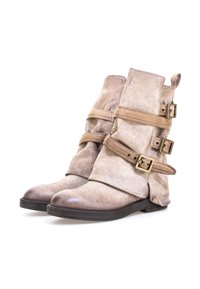 Beżowe zamszowe botki za kostkę z trzema regulowanymi brązowymi paseczkami i mosiężnymi klamrami. Okrągły nosek i elastyczna czarna gumowa podeszwa. Miękka tekstura.