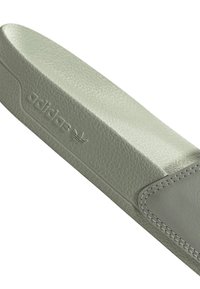Adidas cipőnyelv világoszöld texturált anyagból, varrott szélekkel és domború logó részletekkel. Simább felület, finom mintázattal.