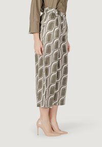 Pantaloni culotte con un motivo geometrico verde e crema, realizzati in tessuto leggero; a vita alta con gamba ampia e vestibilità sartoriale.