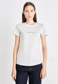 Siva kratka majica z Esprit kratkimi rokavi, narejena iz mehkega bombaža, s krožnim izreza in natisnjenim logotipom Calvin Klein Jeans v črni barvi na prsih.