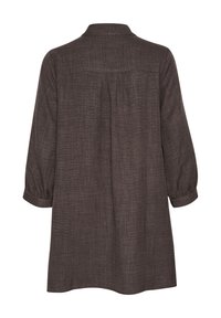 Tunique marron texturée avec col, manches 3/4 et un design à plis au dos. Le tissu semble léger et respirant.