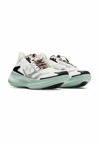 Zapatillas deportivas de malla blanca con acentos en negro y gris, con una suela texturizada en verde menta, cordones beige y un logo plateado en el costado.