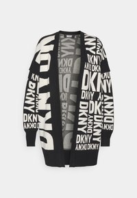 Svart cardigan med stora vita DKNY-logotyper. Öppen framdesign med långa ärmar och ribbade muddarna. Mjuk, texturerad stickad material.