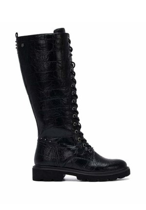 Bota negra de cuero hasta la rodilla con cordones en la parte delantera, patrón texturizado y suela gruesa de goma, vista de lado.
