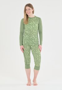 Groen langemouwen shirt en cropped leggings met een herhalend tekstpatroon. De stof lijkt zacht, met een aansluitend ontwerp, en heeft contrasterende manchetten bij de mouwen en benen.
