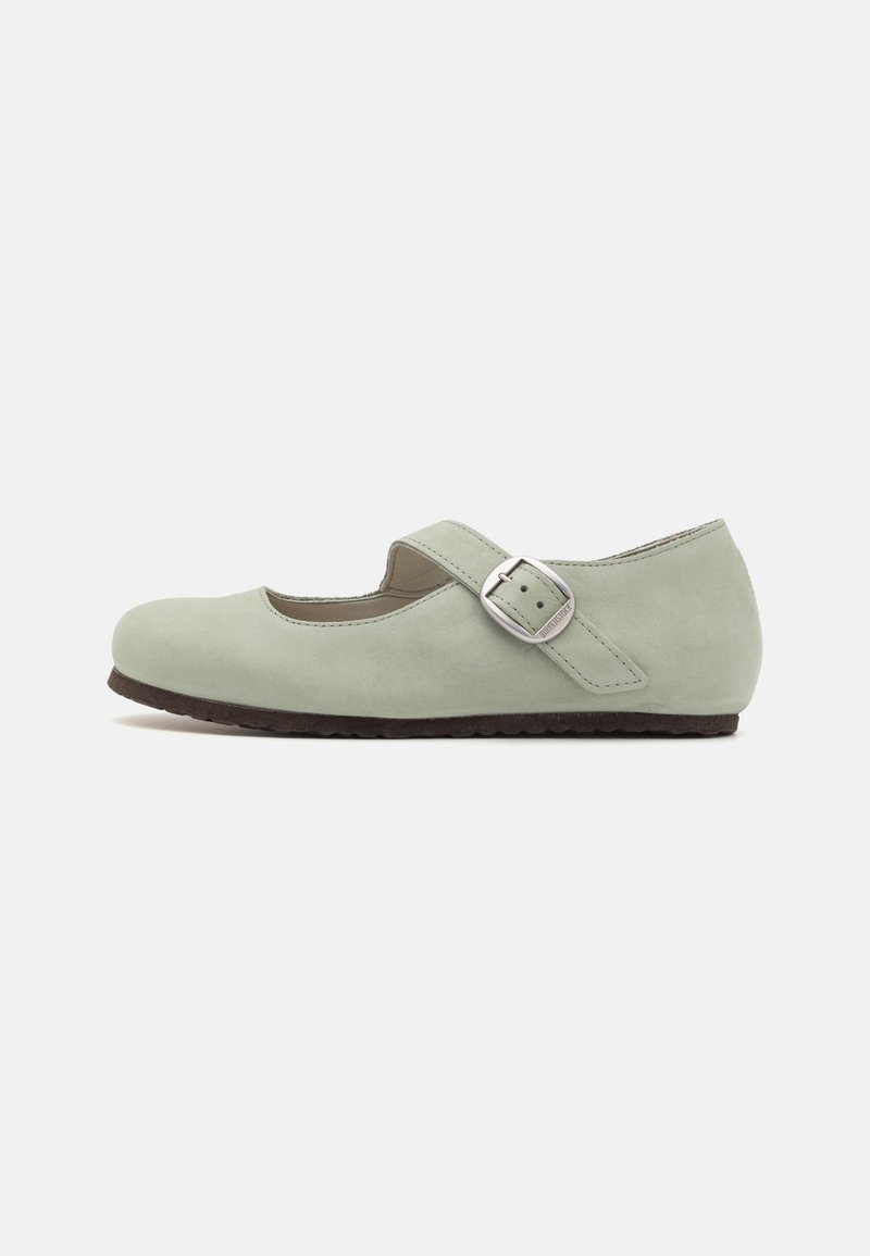 Zapato plano Mary Jane de ante verde claro con puntera redonda, una suela oscura de contraste y una cinta lateral con detalle de hebilla plateada.