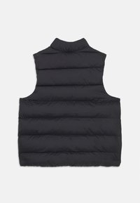 Μαύρο γιλέκο με ψηλό γιακά και χωρίς μανίκια. Περιλαμβάνει οριζόντια ραμμένα τμήματα και λεία, ματ υφή.