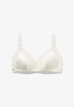 Jasno-kremowy bezprzewodowy biustonosz z koronkowym wykończeniem, gładkimi satynowymi miseczkami i regulowanymi plecionymi ramiączkami; trójkątny kształt i miękka faktura.