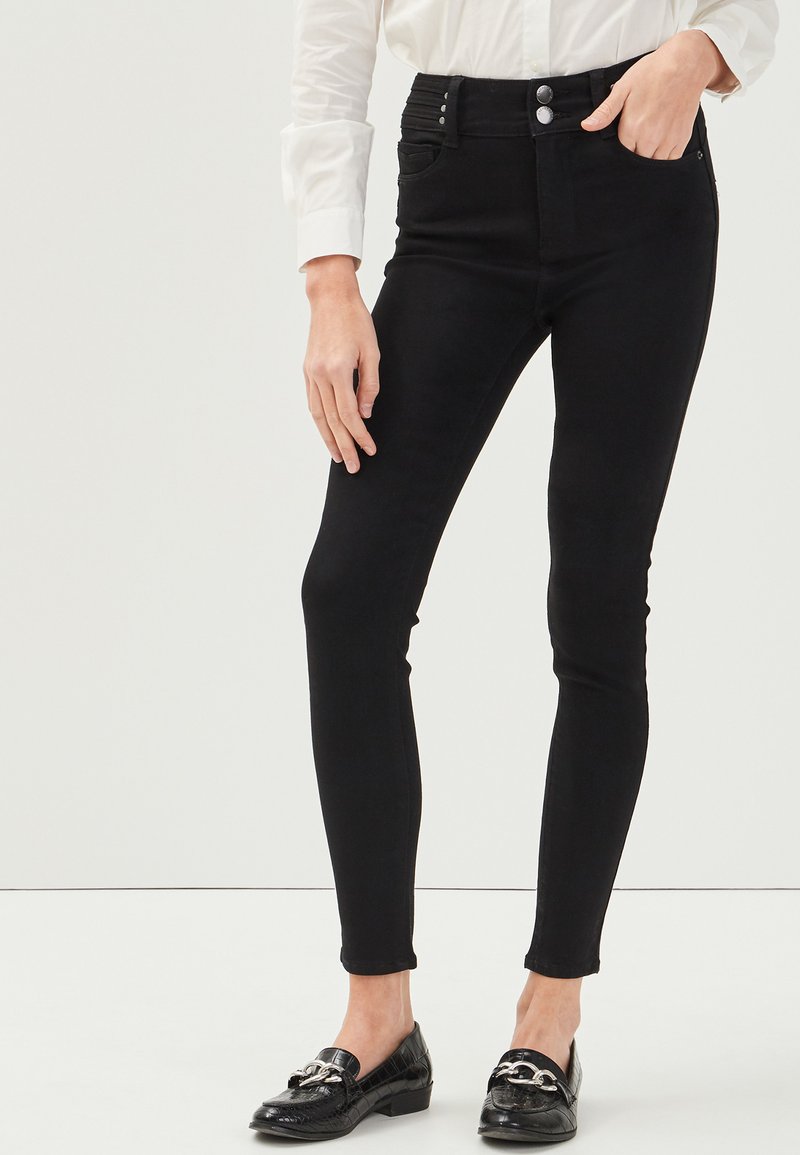 Jeans neri a vita alta con una vestibilità slim, dotati di due tasche anteriori e due bottoni in vita. Tessuto liscio e senza fantasie.