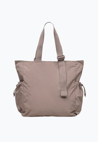 Sac fourre-tout en nylon beige avec deux poches latérales, bandoulière réglable et doubles poignées supérieures. Texture douce avec un design minimaliste.