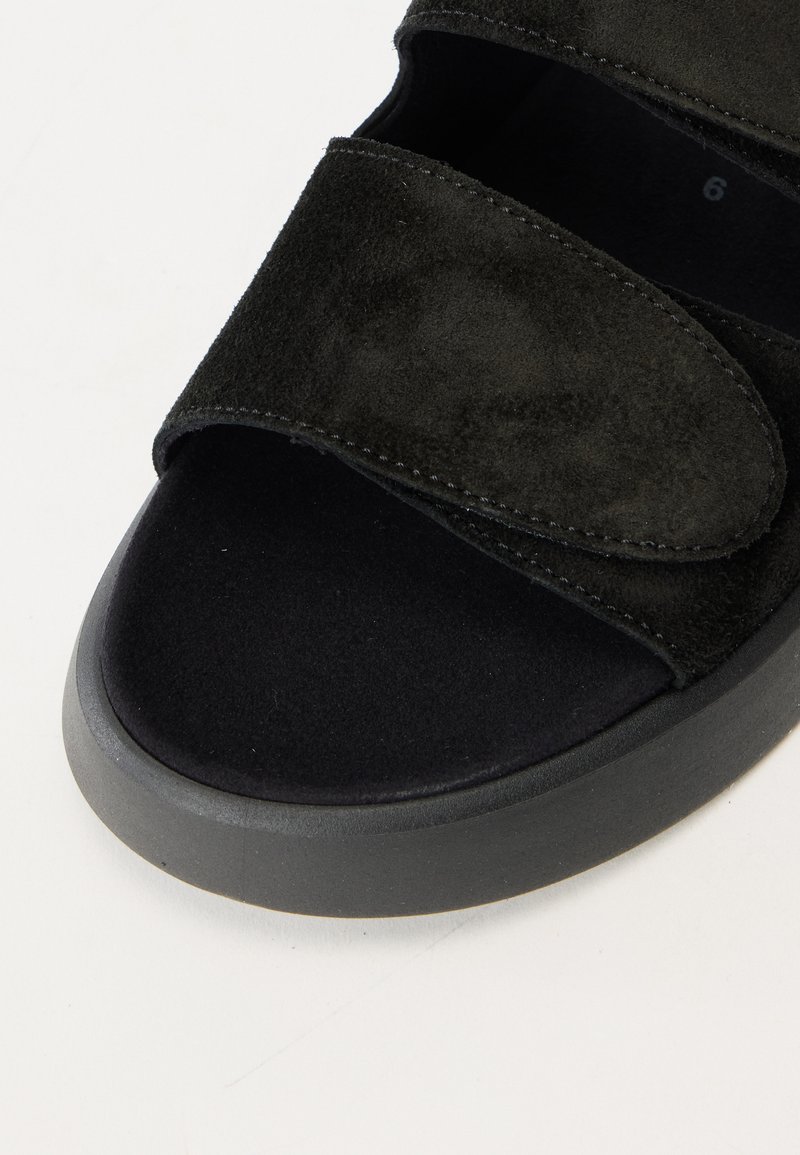 Schwarze Wildledersandale mit zwei breiten Oberriemen, weichem mattem Innenfutter und einer abgerundeten Zehenform. Verfügt über eine strapazierfähige graue Gummisohle.