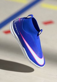 Μπλε αθλητικό παπούτσι με αρμονική σχεδίαση, λείο συνθετικό υλικό, ροζ και λευκές πινελιές, και χαμηλό στυλ με θηλιά για εύκολη εφαρμογή.