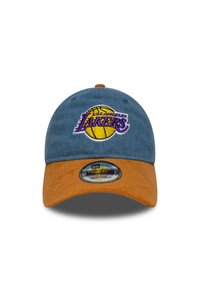 Casquette en denim bleu avec une visière en daim orange, arborant un logo "Los Angeles Lakers" brodé en violet et jaune à l'avant. Taille ajustable.