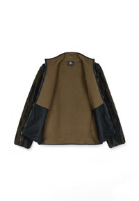 Fleece-takk med brunt og svart leopardmønster på utsiden, kontrasterende beige innside og mesh-lommeaksenter, med glidelåslukking.