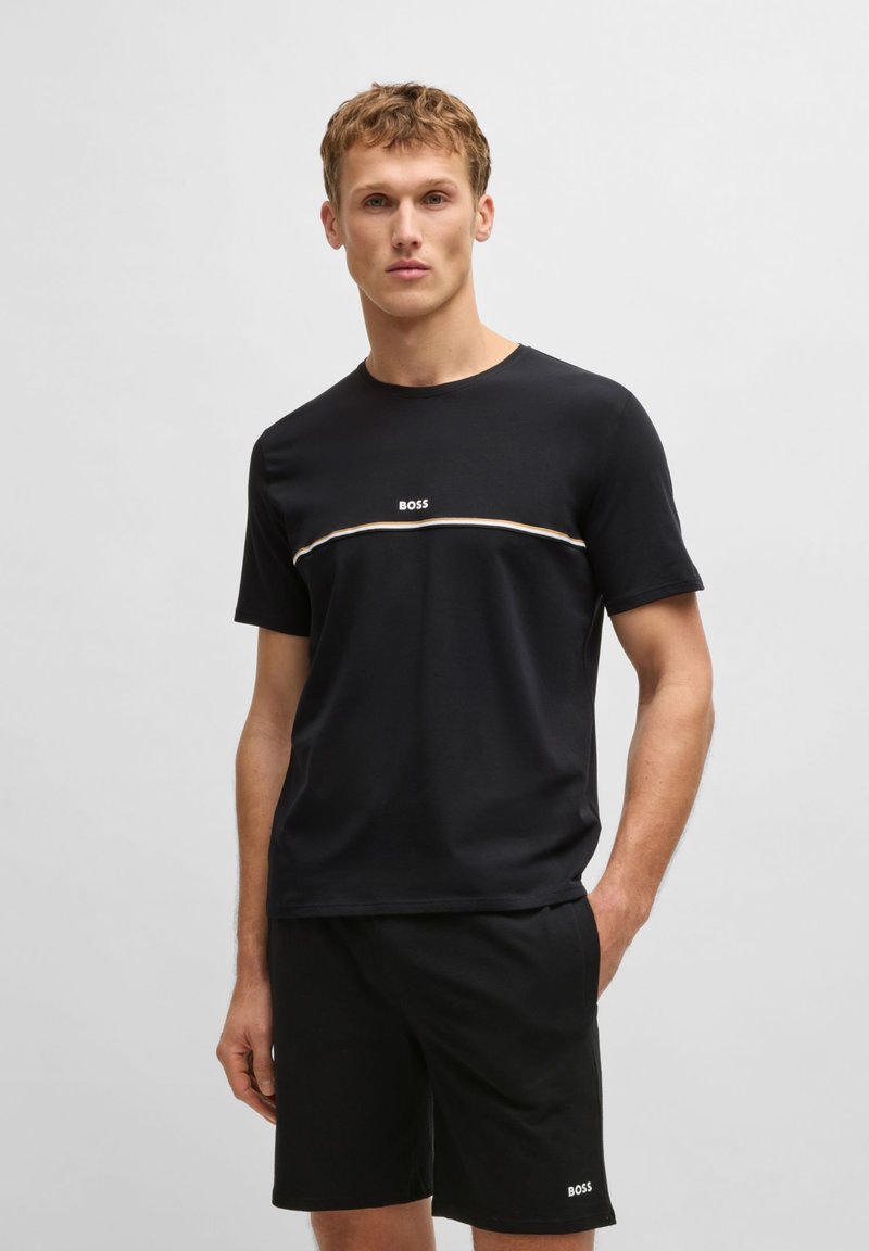 Schwarzes Baumwoll-T-Shirt mit Rundhalsausschnitt und kurzen Ärmeln, mit einem weißen "BOSS"-Logo und einem horizontalen Streifenakzent in Beige und Weiß.