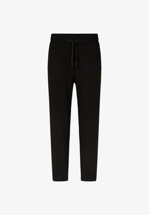 Schwarze Sweatpants mit einem strukturierten Muster, ausgestattet mit einem elastischen Bund und einer Kordel, schmal zulaufenden Beinen und ohne sichtbare Taschen.