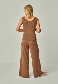 Brauner Strick-Top und weit geschnittene Hose im Set, mit gerippter Textur und lockerer Passform. Der Stoff wirkt weich und atmungsaktiv.