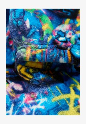 Mīksta flīsa auduma tuvplāns ar spilgti ziliem, dzelteniem, zaļiem un rozā abstraktiem rakstiem, parādot tekstūru un dzīvīgas krāsas.