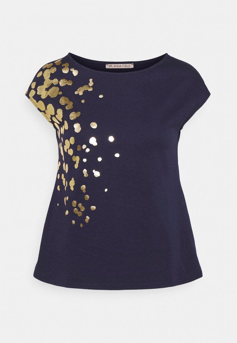 T-shirt bleu marine avec un col rond et des manches courtes, présentant un motif de éclaboussures dorées sur un côté pour ajouter de la texture et du détail visuel.