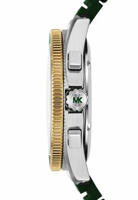 Reloj de acero inoxidable plateado y dorado con una correa de goma verde. Cuenta con un bisel dorado texturizado, una corona circular con el logo "MK" en verde y botones laterales.