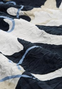 Tissu en coton avec une texture froissée, présentant de bold motifs abstraits bleu marine, blanc et beige, ainsi que des accents bleu clair.