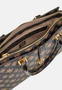 Musta teksturoitu käsilaukku, jossa on kultaiset osat ja ruskea logo-kuvio. Sisäpuolella on useita lokeroita ja vetoketjullisia sulkuja.