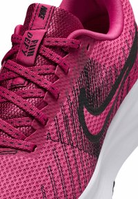 Scarpa da corsa Nike con una tomaia in maglia rosa brillante, dettagli neri e un motivo testurizzato sul lato. Include chiusura con lacci.