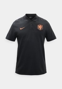 Μαύρο πόλο μπλουζάκι Nike με πορτοκαλί σήμα Nike στην δεξιά πλευρά του στήθους και έμβλημα λιονταριού της ποδοσφαιρικής ομάδας της Ολλανδίας στην αριστερή πλευρά του στήθους.