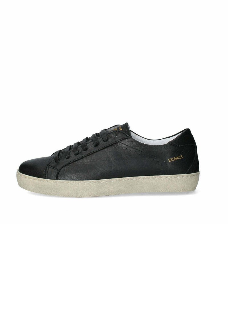 Sneaker in pelle nera con punta arrotondata, lacci piatti e suola in gomma di colore chiaro. Presenta un design minimalista e un logo in rilievo.
