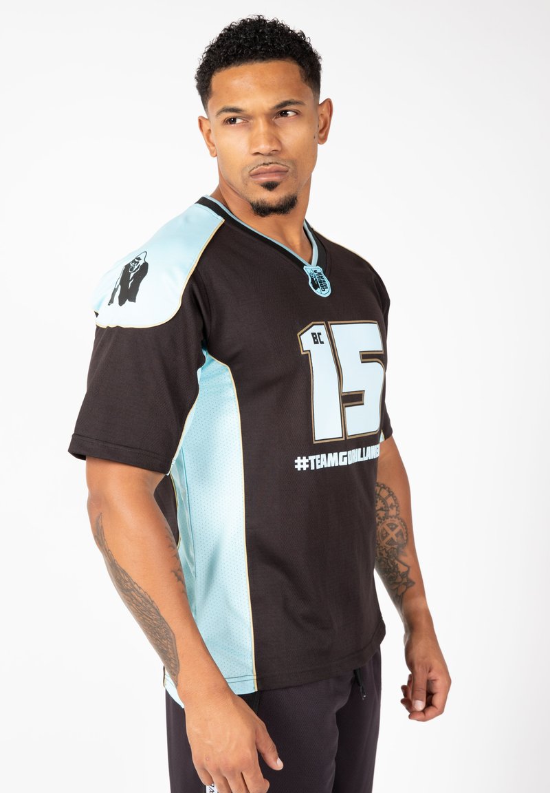 Zwarte short-sleeve jersey met lichtblauwe accenten, voorzien van een groot nummer "15" en de tekst "#TEAMGIRLAMBEE". Mesh-textuur aan de zijkanten, logo op de schouder.