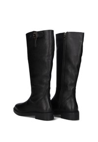 Pair of black knee-high leather boots with textured finish, low stacked heels, side zipper, and buckle strap on one boot.