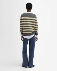 Grijs en geel gestreepte trui met een ronde hals, gemêleerd breiwerk, gecombineerd met een broek met wijde pijpen van denim en een witte blouse eronder.