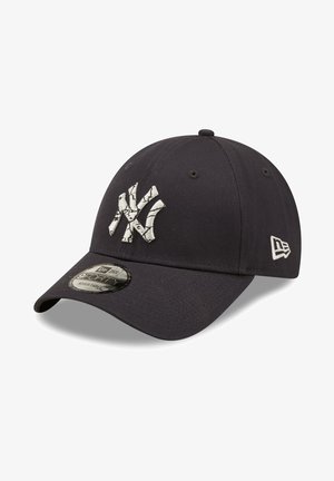 Gorra de béisbol azul marino oscuro con visera curva, que presenta un logo de diseño agrietado en blanco. Fabricada en tela, con parte trasera ajustable y detalle de hardware.