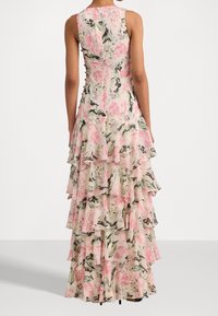 Floral maxi dress featuring a layered design in pink, green, and cream tones. Made of lightweight fabric with a sleeveless, fitted bodice.