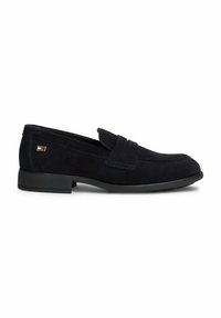 Mocassin homme en daim noir avec un petit talon et un petit logo rectangulaire rouge, blanc et bleu sur le côté près du talon.