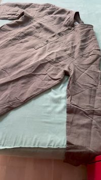 Camicia a maniche lunghe in un morbido tessuto marrone stropicciato, con una fila di bottoni, taschino sul petto e una vestibilità rilassata.