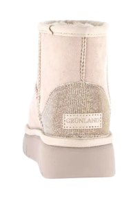 Stivaletto beige realizzato in suede, con un pannello posteriore testurizzato, dettagli cuciti e una suola in gomma chiara con marchio.