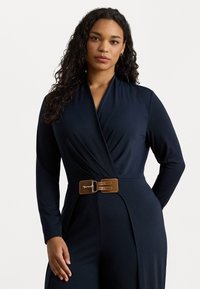 Abito avvolgente navy realizzato in tessuto morbido con maniche lunghe. Presenta una cintura marrone con una fibbia argentata in vita. Design semplice ed elegante.