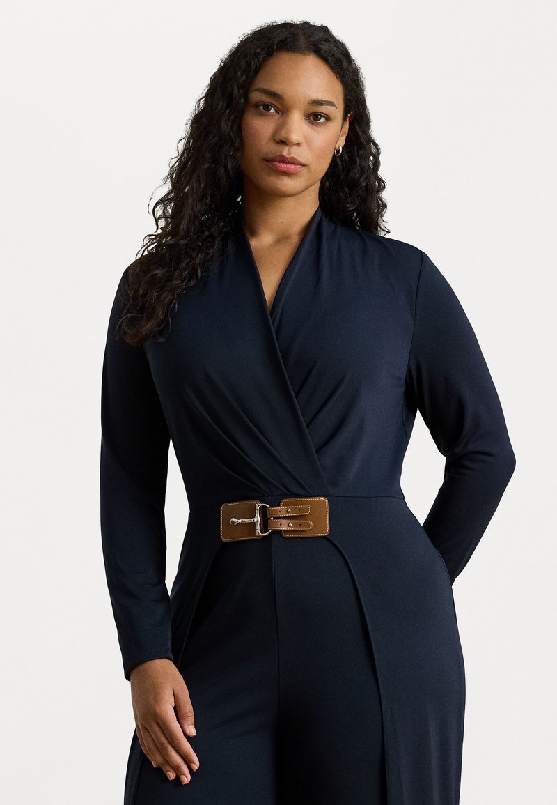 Abito avvolgente navy realizzato in tessuto morbido con maniche lunghe. Presenta una cintura marrone con una fibbia argentata in vita. Design semplice ed elegante.