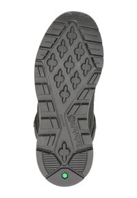 Czarna gumowa podeszwa buta z wielokierunkowym bieżnikiem, z krzyżowymi uchwytami i zielonym akcentem w okolicy pięty.