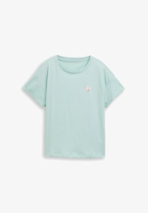 Svijetloplava kratkih rukava majica s podvrnutim rubovima i malim ružičasto-bijelim emblemom lista na lijevoj strani prsa.