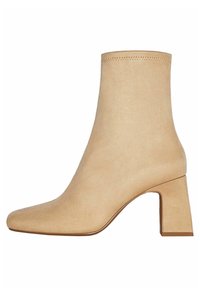 Stivale alla caviglia beige realizzato in morbida suede, con punta quadrata e tacco grosso caratterizzato da una superficie liscia e dettagli di cucitura minimi.